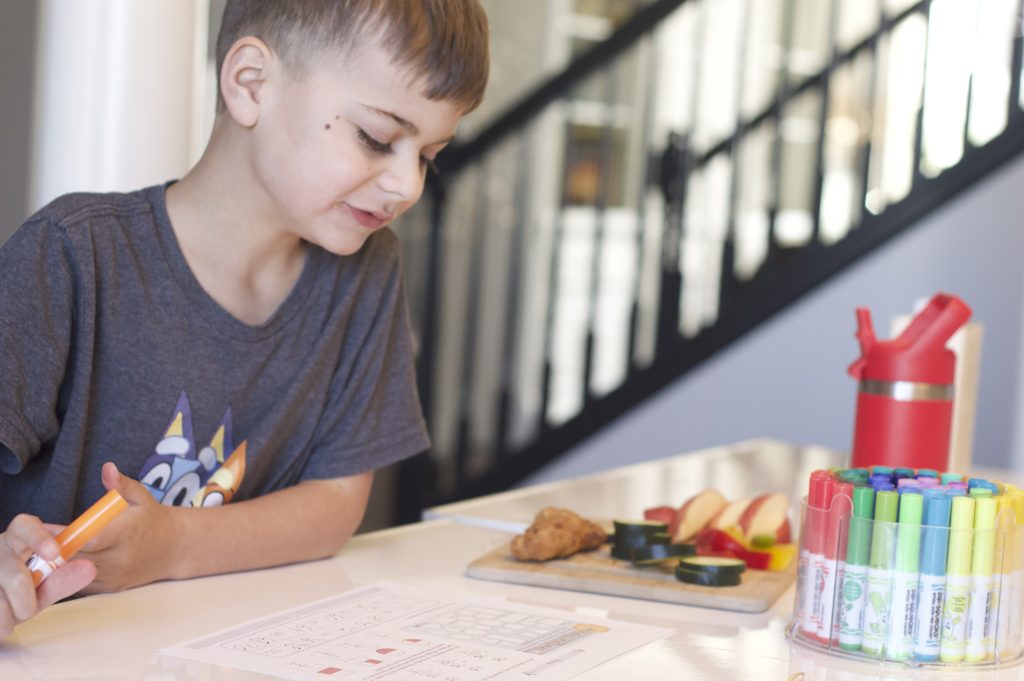 boy smiling working on math page