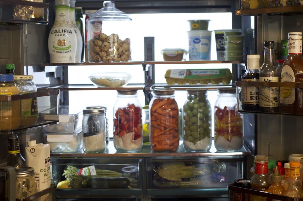 full picture of organized fridge to promote healthy eating with homemade protein balls and washed and prepped produce for the week