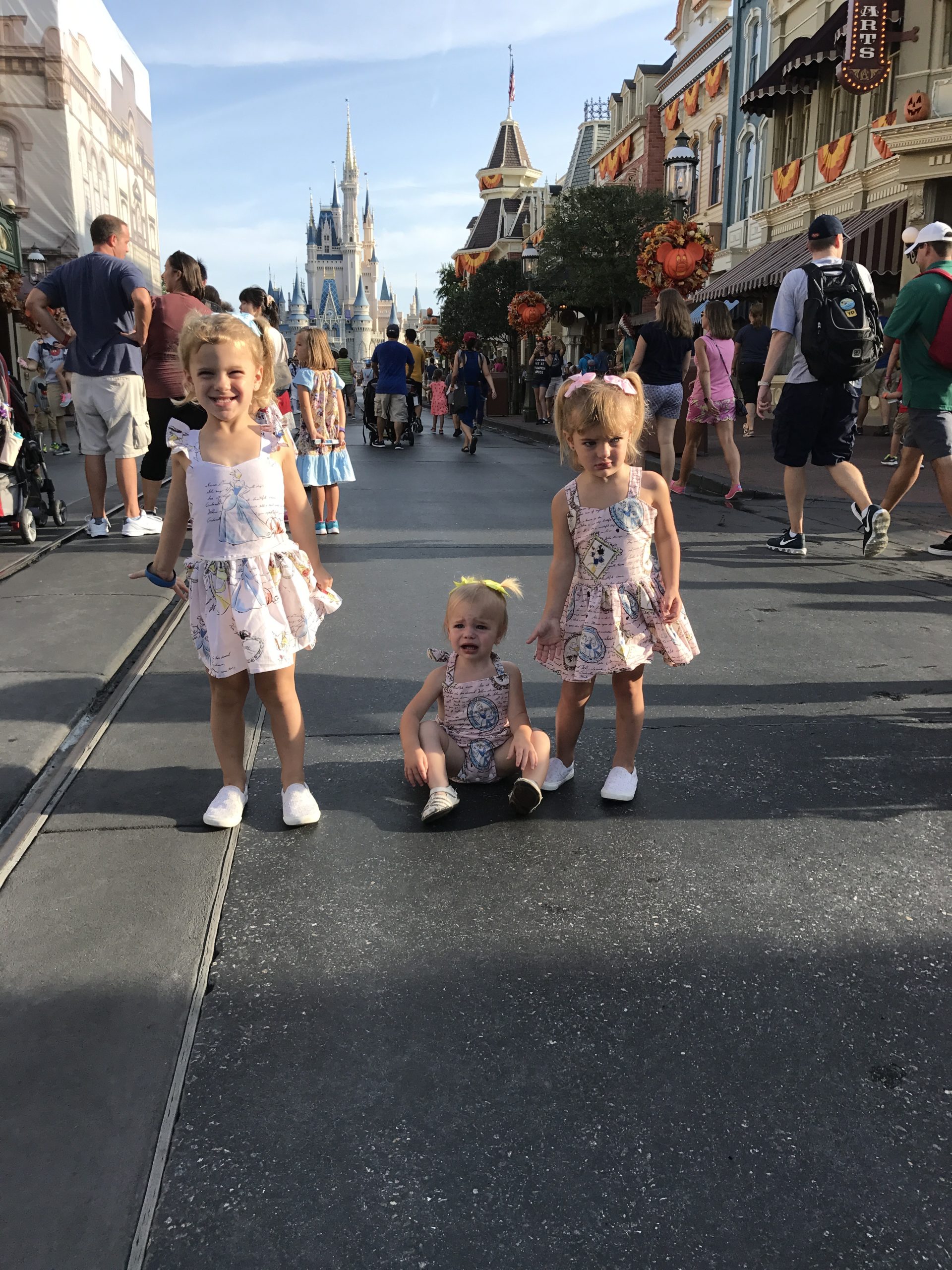 three girls crying in front of Cinderella's castle